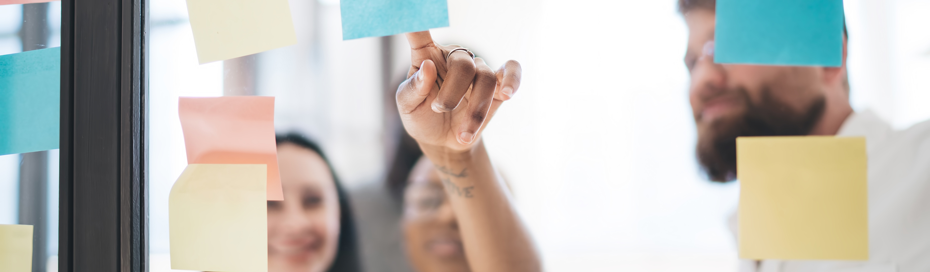 Micro-credentials blog divider Colleagues pointing at post its